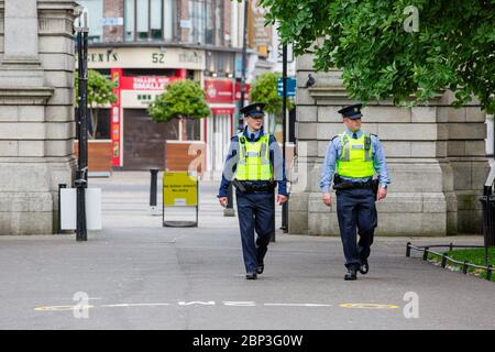 Dublin, Irland. Mai 2020. Zwei Gardai auf Patrouille zu Fuß in St. Stephen`s Green Park durch Fusiliers Arch. Covid-19 Lockdown in Dublin. Stockfoto